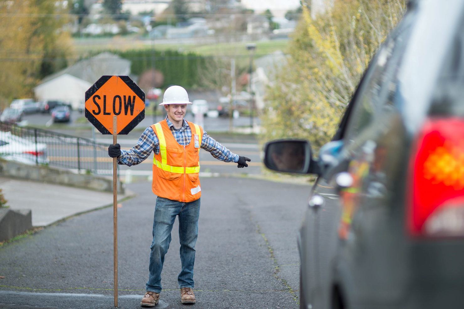 Adult male street flagger directing traffic