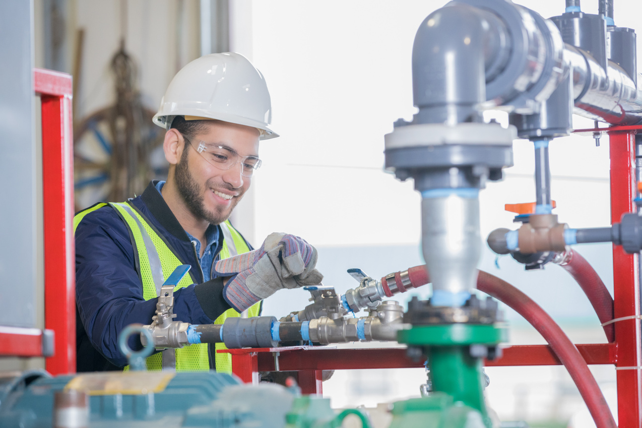 Young engineer working on pipeline equipment for oil and gas company